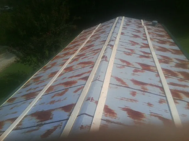 Rusted metal roof panels with new wood purlins before replacement — Storm Damage Roof Repair in Scotts by Roofing Brothers