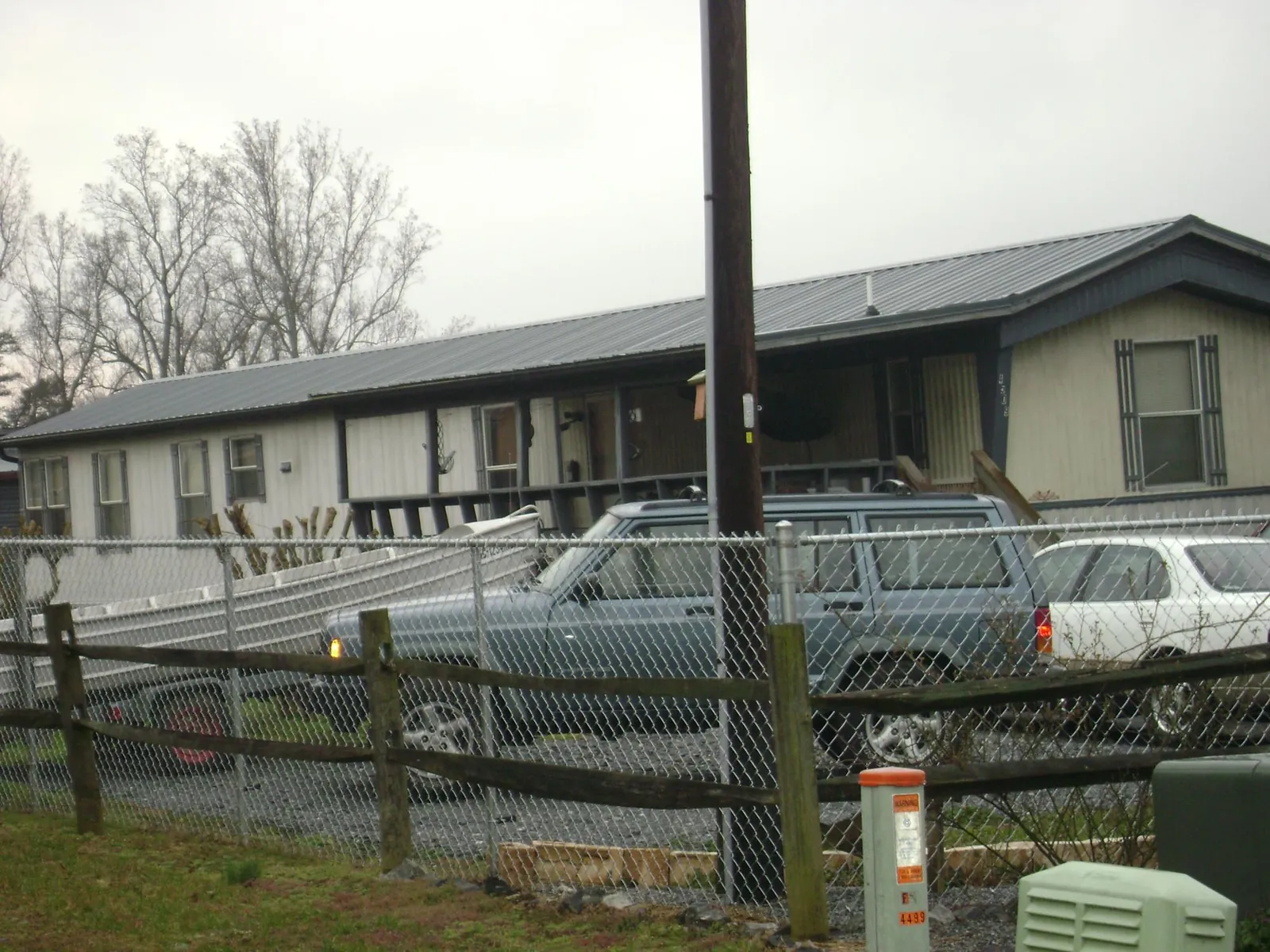 Dark metal roof on a long single story building behind a chain link fence in Scotts