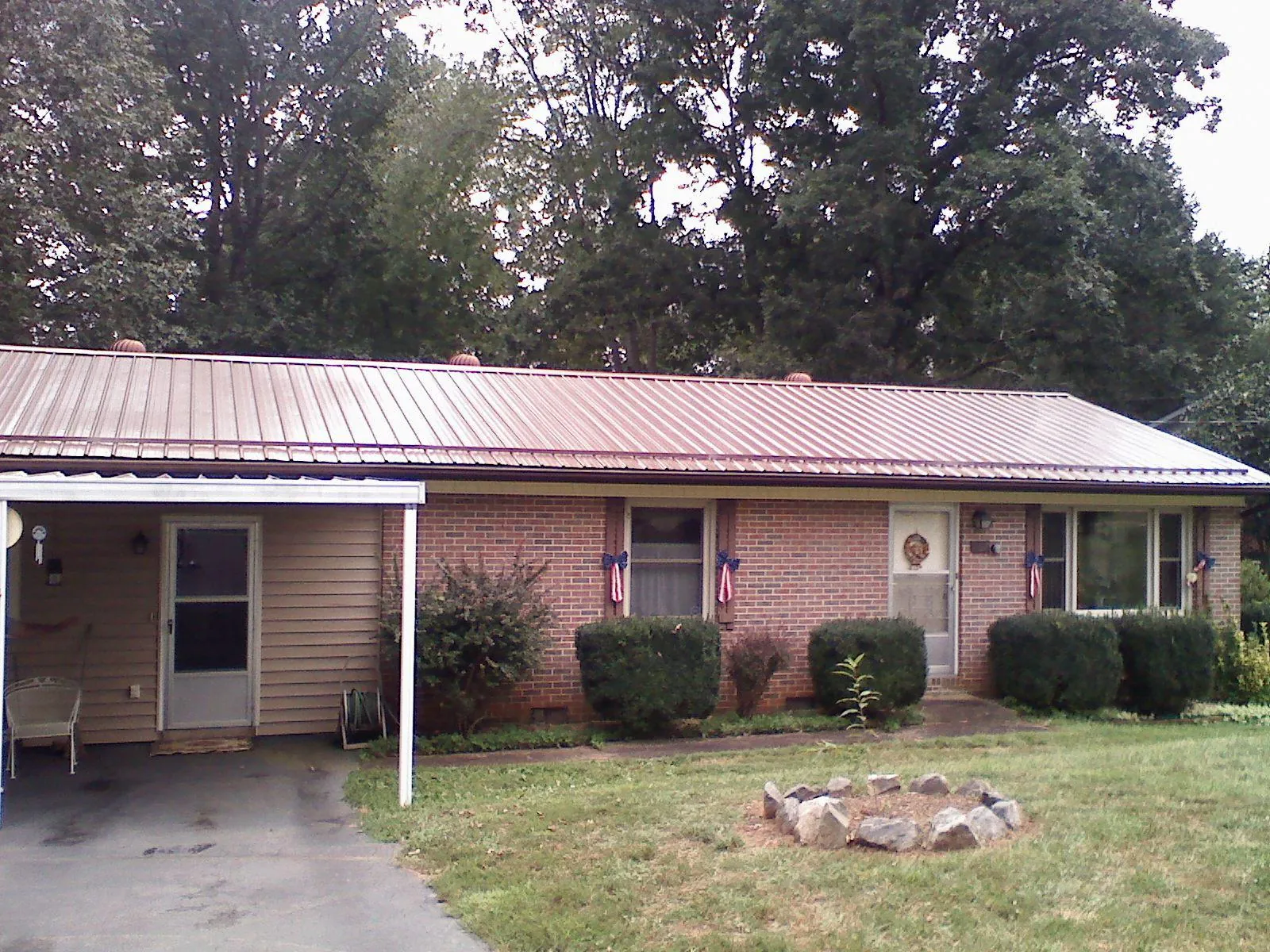 Bronze metal roof and carport on a brick ranch home — Roof Repair work by our crew in Scotts